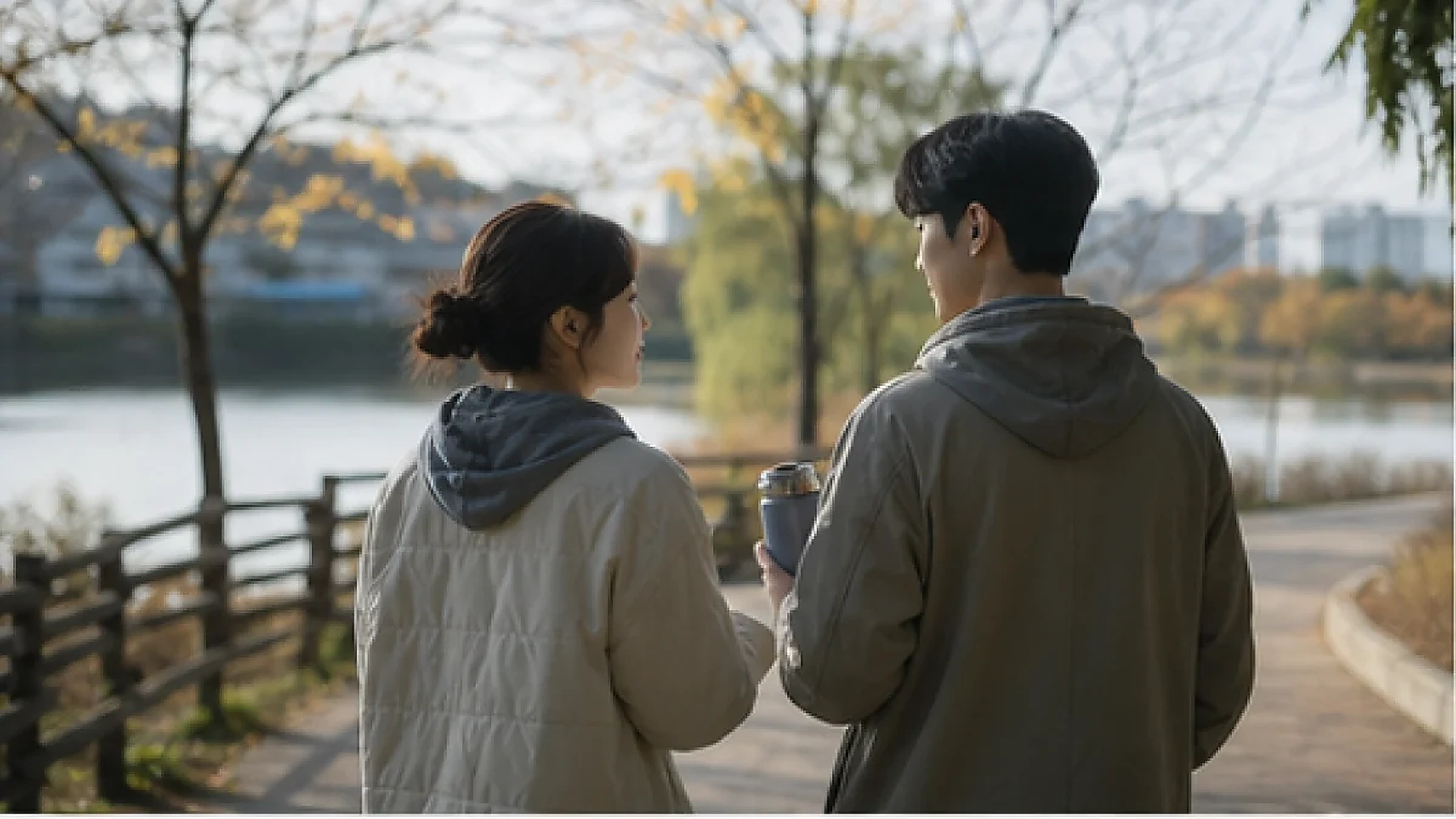 강가 산책로에서 이야기를 나누는 두 사람